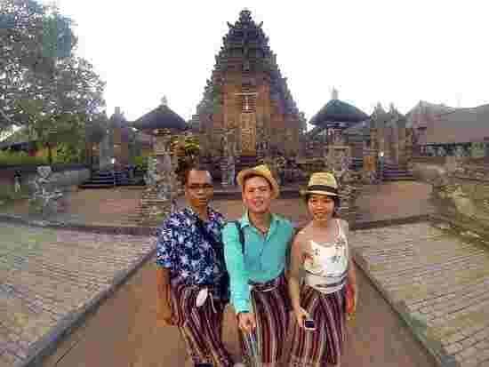 Three tourists posing in front of a Balinese temple – Bali Guide Best Choice for cultural exploration in 2025