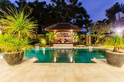 Private pool villa in Seminyak with tropical plants and a relaxing outdoor gazebo, available with exclusive deals through Voucher Villas Seminyak. 