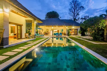 Spacious private pool villa in Seminyak with evening lighting and open-air design, featured in special deals through Voucher Villas Seminyak. 
